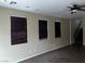 Living room featuring wood floors, three large windows, and staircase access at 8745 Dodds Canyon St, Las Vegas, NV 89131