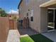 A cozy side yard with faux turf, brick pavers, a rock bed, a brick wall, and a metal gate at 8745 Dodds Canyon St, Las Vegas, NV 89131