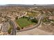 Panoramic aerial view featuring a large grassy field and tennis courts in a vibrant neighborhood at 900 Cantura Mills Rd, Henderson, NV 89052