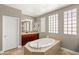 Beautiful bathroom with a soaking tub, dual sinks, dark cabinets, and good natural light at 900 Cantura Mills Rd, Henderson, NV 89052