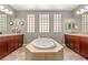 Beautiful bathroom with a soaking tub, dual sinks, dark cabinets, and good natural light at 900 Cantura Mills Rd, Henderson, NV 89052