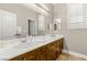 Bathroom featuring dual sinks, wood cabinets, and a large mirror at 900 Cantura Mills Rd, Henderson, NV 89052