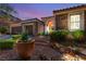 Charming home exterior featuring a stone facade, arched entryway, and manicured landscaping at 900 Cantura Mills Rd, Henderson, NV 89052