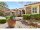 Charming home exterior with stone accents, mature landscaping, and a two-car garage at 900 Cantura Mills Rd, Henderson, NV 89052