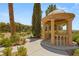 Close-up of a beautiful gazebo featuring columns and seating, set amidst landscaped greenery at 900 Cantura Mills Rd, Henderson, NV 89052