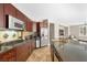Modern kitchen featuring stainless steel appliances, granite countertops, and dark wood cabinets at 900 Cantura Mills Rd, Henderson, NV 89052