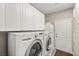 Laundry room with washer, dryer, white cabinets, and utility sink at 900 Cantura Mills Rd, Henderson, NV 89052