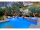 Inviting backyard pool with spa, rock wall, and meticulous landscaping at 900 Cantura Mills Rd, Henderson, NV 89052