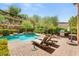 Backyard oasis featuring a private pool, hot tub, lounge chairs, and lush landscaping at 900 Cantura Mills Rd, Henderson, NV 89052