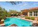 Inviting backyard with a sparkling swimming pool, lounge chairs and a covered patio at 900 Cantura Mills Rd, Henderson, NV 89052