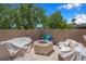 Cozy backyard sitting area with cushioned furniture and a stone fire pit, perfect for outdoor relaxation at 9017 Cotton Rose Way, Las Vegas, NV 89134