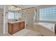 Well-lit bathroom featuring a glass shower, soaking tub, granite vanity and tile flooring at 9017 Cotton Rose Way, Las Vegas, NV 89134