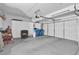 Spacious garage with white storage cabinets, a three car garage door, and epoxy floor at 9017 Cotton Rose Way, Las Vegas, NV 89134