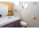 Powder room featuring a stylish mirror, toilet, and sink at 9817 Dardanelle Ct, Las Vegas, NV 89117