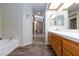 Bathroom featuring bathtub and double sinks with wood-look floors at 9817 Dardanelle Ct, Las Vegas, NV 89117