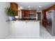 View of a modern kitchen, stainless steel refrigerator, wooden cabinets, and granite countertops at 9817 Dardanelle Ct, Las Vegas, NV 89117