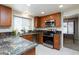 Updated kitchen with wooden cabinets, stainless steel appliances, and sleek granite countertops at 9817 Dardanelle Ct, Las Vegas, NV 89117