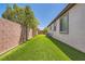 Side yard featuring artificial turf and mature landscaping at 10121 Iron Wood Peak Ave, Las Vegas, NV 89166