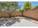 Low maintenance backyard with a concrete patio and desert-friendly landscaping around the brick perimeter at 10121 Iron Wood Peak Ave, Las Vegas, NV 89166