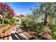 Beautifully landscaped park walkway featuring lush greenery and a charming pergola with benches at 10121 Iron Wood Peak Ave, Las Vegas, NV 89166