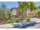 Charming single-story home with stone accents, lush landscaping, and a well-maintained front yard at 10121 Iron Wood Peak Ave, Las Vegas, NV 89166