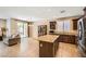 Modern kitchen with stainless appliances, dark wood cabinets, granite countertops and an open dining area at 10121 Iron Wood Peak Ave, Las Vegas, NV 89166