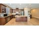 Modern kitchen with stainless appliances, tile floors, dark wood cabinets and center island with granite countertops at 10121 Iron Wood Peak Ave, Las Vegas, NV 89166