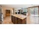 Kitchen island and open concept living with dark wood cabinets, tile floors and granite countertops at 10121 Iron Wood Peak Ave, Las Vegas, NV 89166