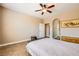 Neutral primary bedroom with ceiling fan and access to the en suite bathroom at 10121 Iron Wood Peak Ave, Las Vegas, NV 89166