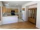Well-lit kitchen features wood cabinets, tile countertops and backsplash, and breakfast bar at 10357 Bent Willow Ave, Las Vegas, NV 89129