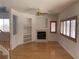 Cozy living room featuring hardwood floors, a fireplace, built-in shelves, and shuttered windows at 10357 Bent Willow Ave, Las Vegas, NV 89129