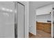 Bathroom with glass door shower, and view of a closet with wooden cabinet and wood-look floors at 10450 Gold Shadow Ave, Las Vegas, NV 89129