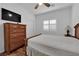 Inviting bedroom with a wooden dresser, a ceiling fan, and a comfortable bed at 10450 Gold Shadow Ave, Las Vegas, NV 89129