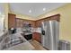 Modern kitchen featuring stainless steel appliances, granite countertops, and wood cabinets at 10450 Gold Shadow Ave, Las Vegas, NV 89129