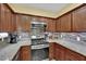 Stylish kitchen featuring stainless steel appliances, granite countertops, and wood cabinets at 10450 Gold Shadow Ave, Las Vegas, NV 89129