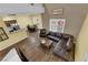 Open-concept living space with a leather sofa, a dining area, and natural light at 10450 Gold Shadow Ave, Las Vegas, NV 89129