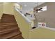 Staircase with wood steps, yellow walls, and a modern ceiling fan with a window at 10450 Gold Shadow Ave, Las Vegas, NV 89129