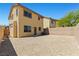 A sunny backyard featuring gravel landscaping, a brick wall, and the exterior of the house at 10650 Little Horse Creek Ave, Las Vegas, NV 89129