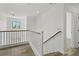 Hallway features wood railing, bright neutral paint, and wood floors at the top of stairs at 10650 Little Horse Creek Ave, Las Vegas, NV 89129