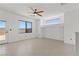 Large empty living room with a ceiling fan, neutral walls, tile floors, and outdoor access at 10650 Little Horse Creek Ave, Las Vegas, NV 89129