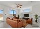 Staged living room with ceiling fan, neutral colors, tile floors, and comfortable furniture at 10650 Little Horse Creek Ave, Las Vegas, NV 89129