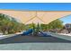 Community playground featuring a shaded play structure, multiple slides, and benches at 10650 Little Horse Creek Ave, Las Vegas, NV 89129