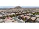 An aerial view features a home situated in a neighborhood with desert landscaping, mountain views, and paved roads at 10650 Little Horse Creek Ave, Las Vegas, NV 89129