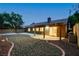 Inviting backyard featuring covered patio, manicured gravel landscaping, and exterior lighting at 10712 Aire Dr, Las Vegas, NV 89144