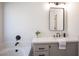 Bathroom featuring a modern vanity, soaking tub with matte black fixtures, and neutral decor, offering a relaxing space at 10712 Aire Dr, Las Vegas, NV 89144