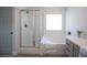 Well-lit bathroom with a soaking tub, glass-enclosed shower, and a gray vanity, providing a spa-like atmosphere at 10712 Aire Dr, Las Vegas, NV 89144