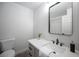 Modern bathroom with a stylish vanity, framed mirror, quartz counters, and a toilet at 10712 Aire Dr, Las Vegas, NV 89144