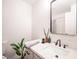 Bright bathroom with a white vanity, sleek black fixtures, and a decorative mirror at 10712 Aire Dr, Las Vegas, NV 89144