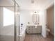 Bright bathroom featuring a modern vanity, soaking tub with glass enclosure, and separate toilet for added privacy at 10712 Aire Dr, Las Vegas, NV 89144