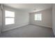 Spacious bedroom with neutral carpet, two windows, and freshly painted walls at 10712 Aire Dr, Las Vegas, NV 89144